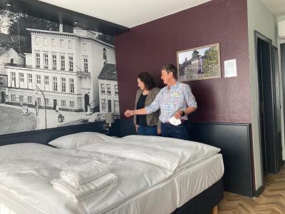 Frau Schmidthausen und Frau Haswell neben historischer Fototapete im Akzent Hotel